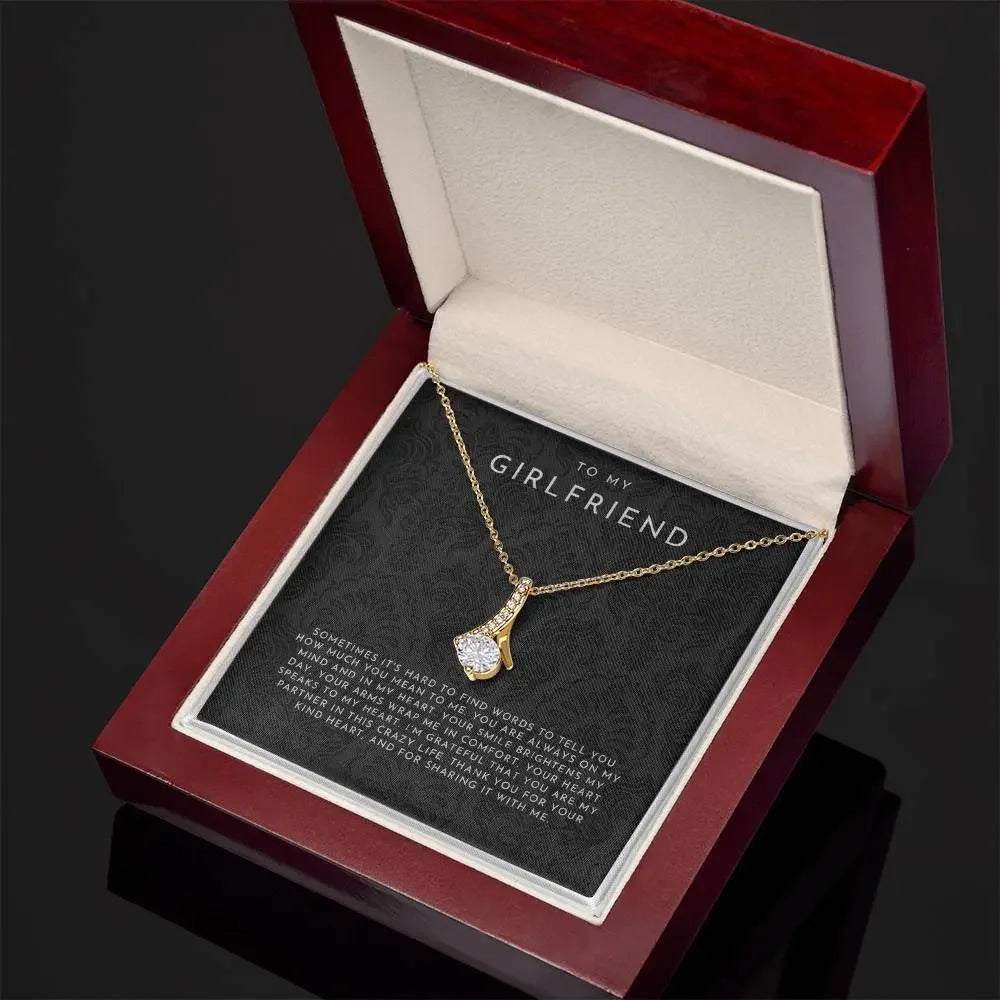 Gold necklace with a diamond pendant in a red wooden jewelry box with a loving message to my girlfriend